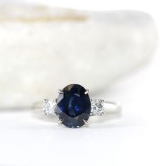 a blue sapphire and diamond ring on a white background