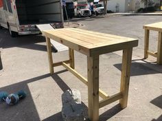 two wooden benches sitting in the middle of a parking lot