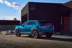 a blue volkswagen suv parked in front of a building