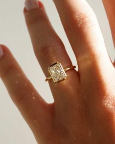 a woman's hand with a gold ring on it and a diamond in the middle