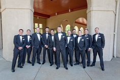 a group of men in tuxedos are posing for a photo outside the church