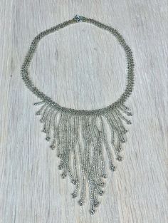 "This light grey beaded fringe necklace would look great with a cocktail dress of almost any colour.  Necklace length 37 cm (14.6\"), longest fringe 10 cm (4\") Very good vintage condition.  Check out the other jewelry I have for sale: https://www.etsy.com/shop/IamMiaFinland?section_id=28315483 SHIPPING - I ship worldwide via DHL global mail.  - Please allow 1 to 4 weeks for the package to arrive if you live overseas. - Europe 2 - 10 business days. - DHL Express delivery service available for pu Silver Tassel Necklace For Party, Elegant Bib Necklace With Beaded Chain, Elegant Tassel Necklace For Party, Elegant Beaded Fringe Jewelry, Elegant Long Tassel Necklace With Fringe, Elegant Beaded Bib Necklace For Evening, Elegant Embellished Beaded Necklaces For Party, Elegant Embellished Beaded Necklace For Party, Elegant Silver Beaded Tassel Necklace