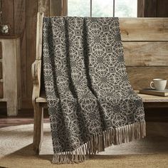 a black and white blanket sitting on top of a wooden chair