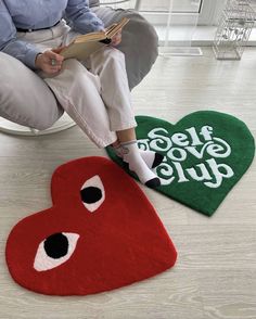 a person sitting on a chair with two heart shaped rugs