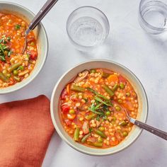 two bowls of vegetable soup on a table