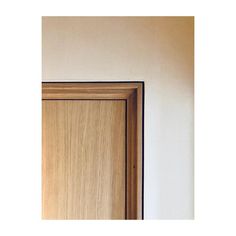 a wooden door is shown against a white wall