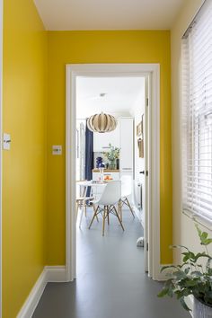 the hallway is painted bright yellow with white trim