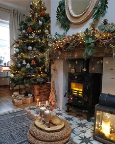 a living room with a christmas tree and lit candles in front of the fire place