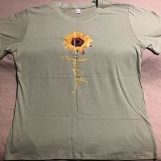 Xl-Sized Sage Green Women’s T-Shirt. Super Cute Faith Proclaiming Casual And Cool Shirt . Portrays Faith As A Sunflower Always Believing The Sun Will Rise Again And Waiting Patiently As Steadily As Always, Facing The Sunshine And The Positive. Brand New And From A Non-Smoking And Pet-Free Household. Cotton Crew Neck T-shirt With Sunflower Design, Casual Cotton T-shirt With Sunflower Print, Cotton T-shirt With Sunflower Design, Casual Sunflower Design T-shirt With Relaxed Fit, Casual Sunflower Design T-shirt In Relaxed Fit, Relaxed Fit Cotton T-shirt With Sunflower Design, Relaxed Fit Short Sleeve T-shirt With Sunflower Design, Casual Relaxed Fit Sunflower T-shirt, Casual Relaxed Fit T-shirt With Sunflower Design