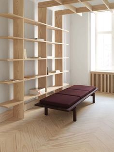 an empty room with bookshelves and a bench in the middle on the floor