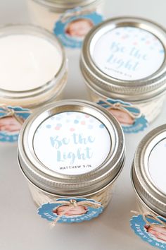 small jars filled with baby's first milk are sitting on a white tablecloth