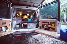 the back end of an rv with its doors open and furniture in the cargo area