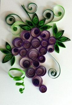 a bunch of grapes with green leaves and swirls on the top are made out of paper