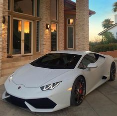 a white sports car parked in front of a house