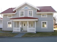 a gray house with white trim and red roof