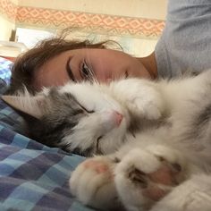 a woman laying in bed with her cat