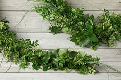 some green plants are laying on a white wooden surface with one plant in the middle