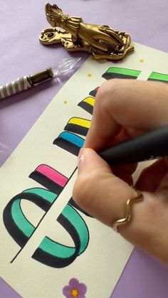 a person is writing on a piece of paper next to some scissors and other crafting supplies