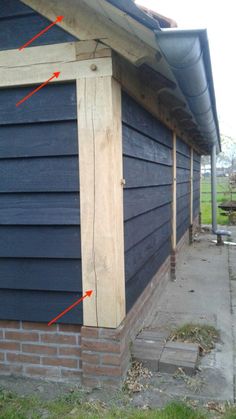 the side of a blue house with red arrows pointing to it