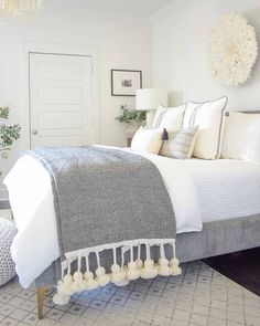 a bedroom with a large bed, mirror and rugs on the floor in front of it