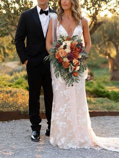 a bride and groom posing for a photo in front of an olive tree at sunset