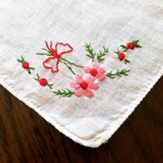 "This listing is for an embroidered vintage handkerchief. Made of linen and with a rolled edge, there is an embroidered pink daisy like flower posey tied in a red bow embroidered in one corner. There is one small spot that has been faintly stained and a tiny hole was created, see picture. Handy retro gift for someone who has allergies or will cry the happiest of tears on someone's wedding day.  Use it as it was intended as a handkerchief. Or... frame it in an embroidery hoop and displayed with o Embroidered Flower Handkerchiefs For Gifts, Flower-shaped Embroidered Handkerchiefs For Gifts, Flower Shaped Embroidered Handkerchiefs For Gift, Embroidered Flower Handkerchiefs As Gift, Spring Handkerchiefs With Floral Embroidery As Gift, Floral Embroidered Handkerchiefs For Spring Gift, Spring Floral Embroidery Handkerchiefs As Gift, Spring Gift Handkerchiefs With Floral Embroidery, White Embroidered Flower Shaped Handkerchiefs