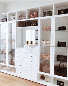 a white closet filled with lots of purses and handbags on top of shelves