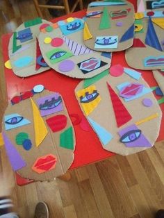 a child's hand is on the floor next to some paper plates with different shapes and sizes