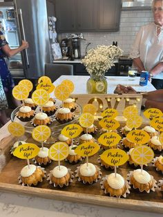 cupcakes are arranged on a tray with lemon slices