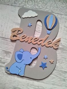 a wooden sign with an elephant and hot air balloon in the shape of the letter b