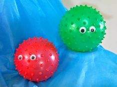 two balls with googly eyes sitting on a blue sheet