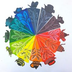 an image of a rainbow colored wheel with leaves and acorns in the center