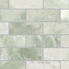 a white tile wall with green and gray tiles