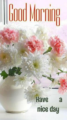 a white vase filled with pink and white flowers on top of a window sill