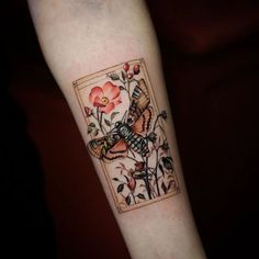 a tattoo on the arm of a person with a flower and bird in front of it