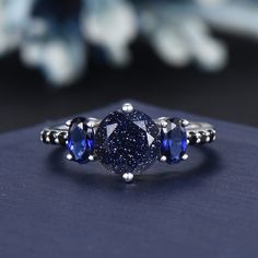 a blue diamond ring sitting on top of a table