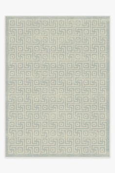 a white rug with an intricate design on the front and back side, in shades of blue