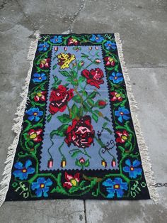 a blue rug with flowers on it sitting on the ground in front of a building