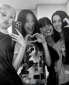 black and white photograph of four girls making heart shape with their hands