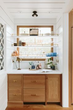 a kitchen with wooden cabinets and white counter tops, along with open shelving above the sink