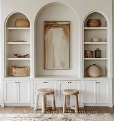 two stools in front of white built - in shelves with baskets on each shelf