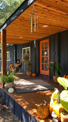 a porch covered in lots of pumpkins and potted plants