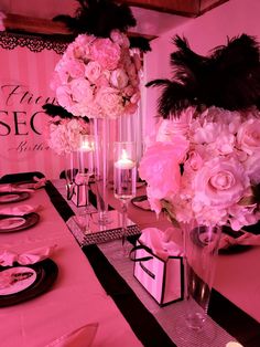 the table is set with pink flowers and candles