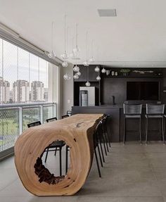 a large open kitchen and dining room area with black cabinets, counter tops, and bar stools