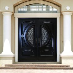 a black double door with two sidelights in front of a beige stucco building and white pillars