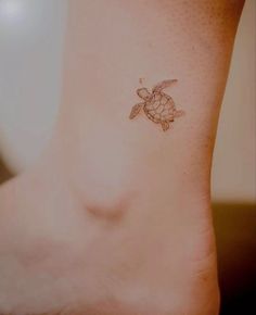 a small tattoo on the ankle of a woman's foot with a sea turtle