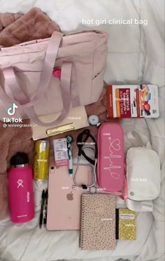 the contents of a pink bag are laid out on a white bed with sheets and pillows