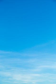 two people standing on the beach flying a kite