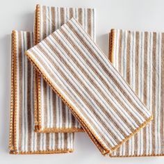 three brown and white striped napkins sitting on top of each other