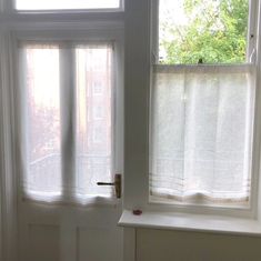 two windows with white curtains in front of them